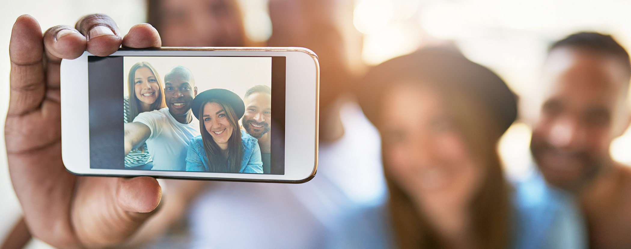 Four adults taking a selfie after cosmetic dentistry in Sterling Heights