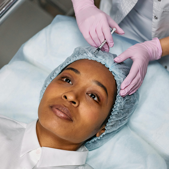 Woman getting an injection in her forehead