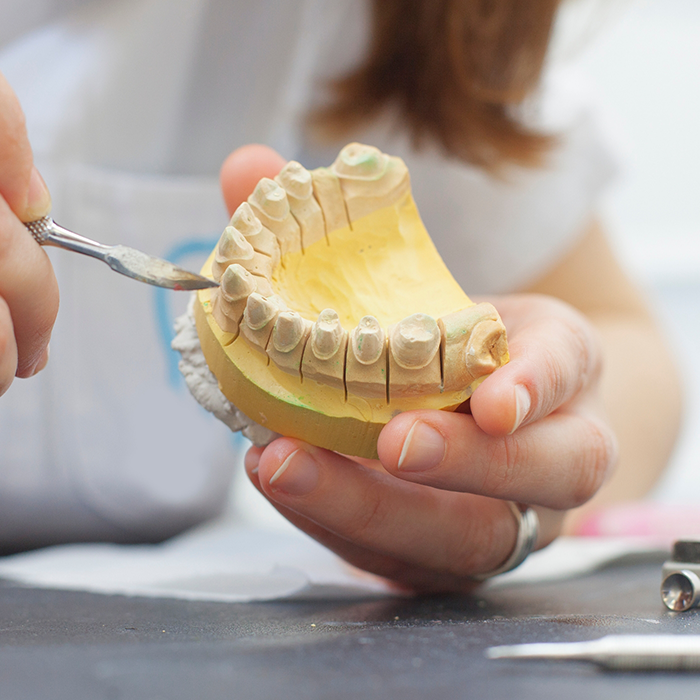 Dental ceramist designing a dental bridge