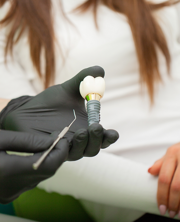Dentist showing a dental implant to a patient