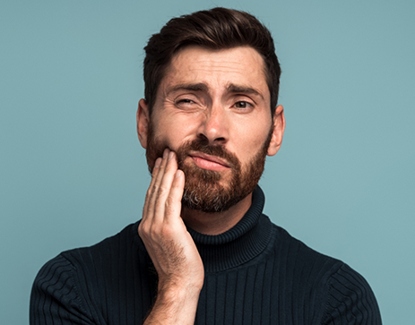 Man holding the side of his face in pain