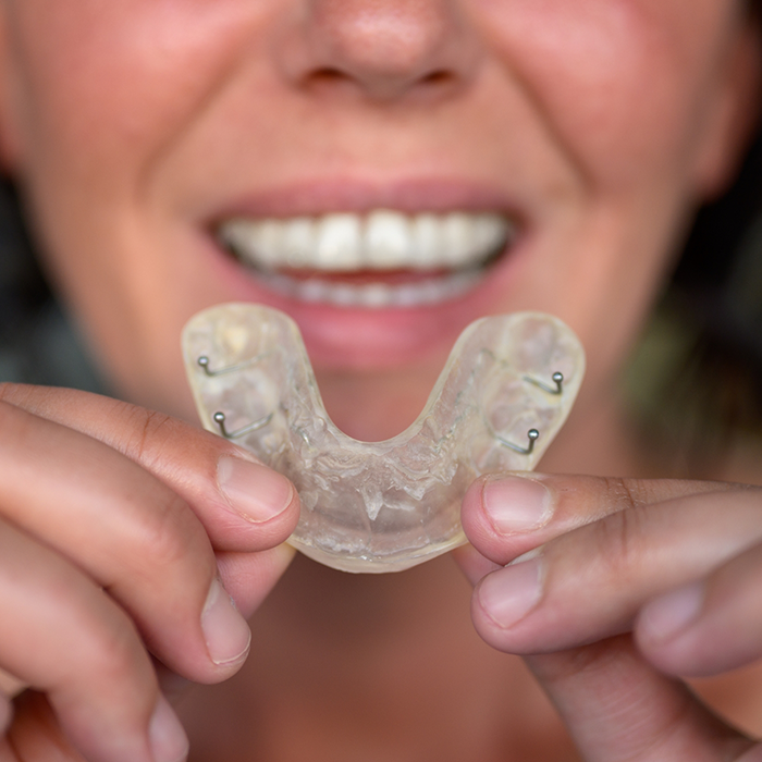 Person holding a clear nightguard tray
