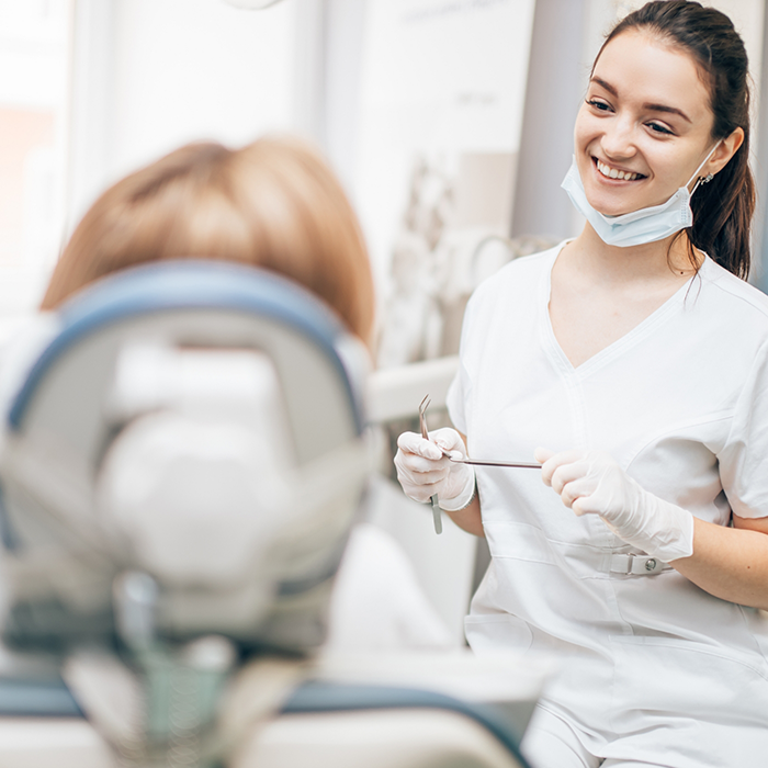 Dental team member talking to a patient in the treatment chair