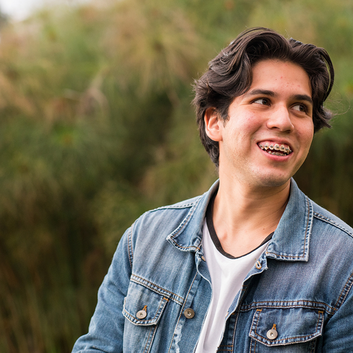 Young man with braces smiling outdoors